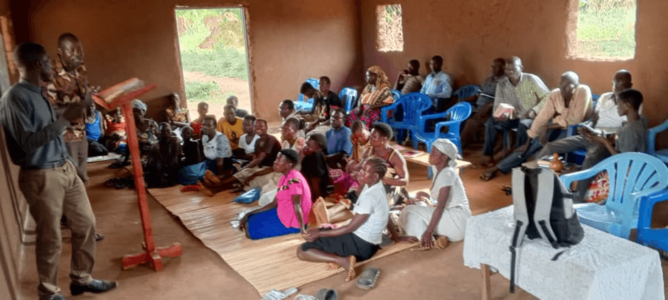 A congregation gathered inside a simple church building.
